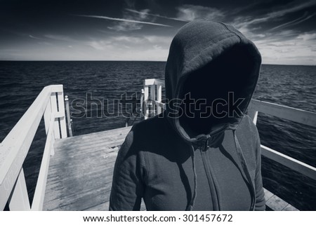 [[stock_photo]]: Faceless Hooded Unrecognizable Woman At Ocean Pier Abduction Co