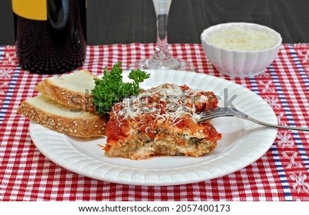 Foto d'archivio: One Serving Of Eggplant Parmesan With Sides Of Wine And Parmesan