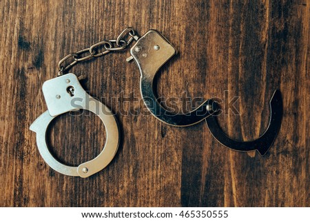 Foto stock: Uncuffed Open Hand Cuffs On Wooden Desk Top View