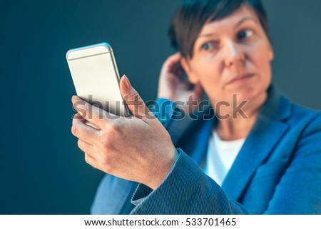 Stok fotoğraf: Businesswoman With Short Hair Checking Hairstyle Using Mobile Ph