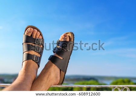 Сток-фото: Male Feet In Leather Slippers Relaxing On Balcony