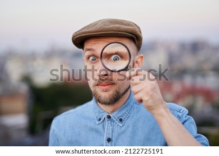 Stockfoto: Person Looking Into Jeans Using Magnifying Glass