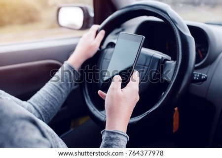 Stok fotoğraf: Woman Simultaneously Driving Car And Reading Text Message