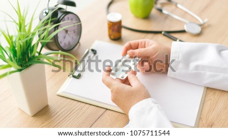 Foto stock: Female Doctor Holding Unlabeled Generic Tablets