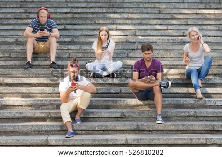 ストックフォト: Woman Sitting Outdoors In Park Using Mobile Phone Listening Music With Earphones