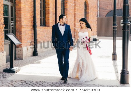 Imagine de stoc: Horizontal Portrait Of Affectionate Lovely Married Couple Keeps Hands Together Walk Outdoor Look