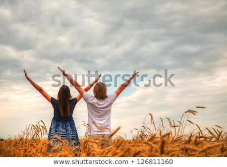 Foto stock: Couple Staying With Raised Hands At A Wheat Field