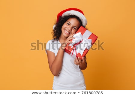 Foto stock: Girl Dressed In Santa Hat With A Christmas Gift