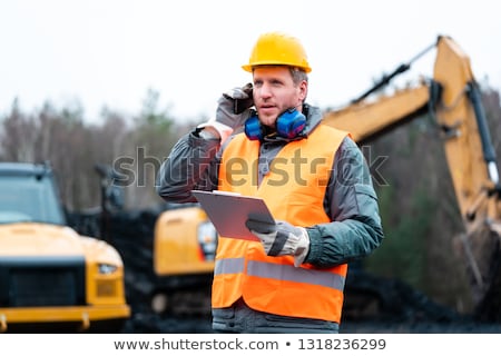 ストックフォト: Portrait Of A Quarry Worker Standing In Front Of Excavator