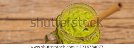 Zdjęcia stock: Green Tea Latte With Ice In Mason Jar And Straw On Wooden Background Homemade Iced Matcha Latte Tea