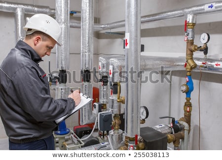 Stockfoto: Technician Inspecting Heating System In Boiler Room