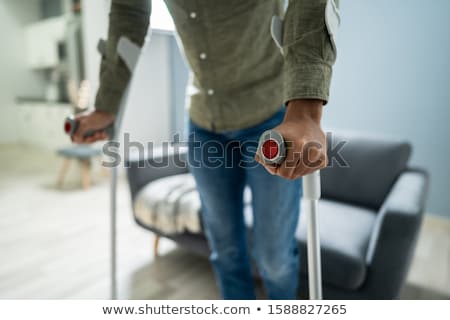 Stock photo: Disabled Man Using Crutches To Walk