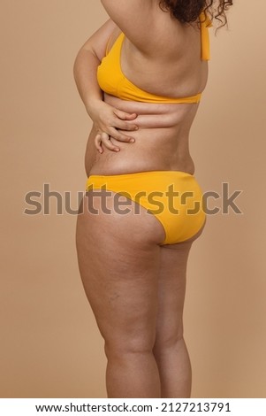 Stockfoto: Closeup Of A Female Backside In A Yellow Swimsuit