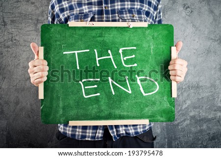 [[stock_photo]]: Man Holding Green Chalkboard With The End Title