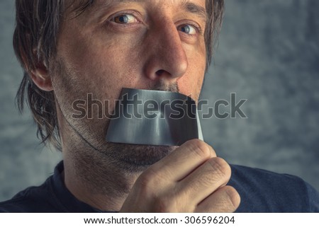 ストックフォト: Fighting Censorship Man Removing Duct Tape From Mouth