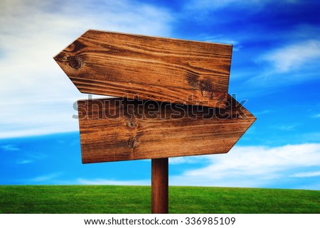 Foto stock: Blank Rustic Opposite Direction Wooden Sign On Grassland Field