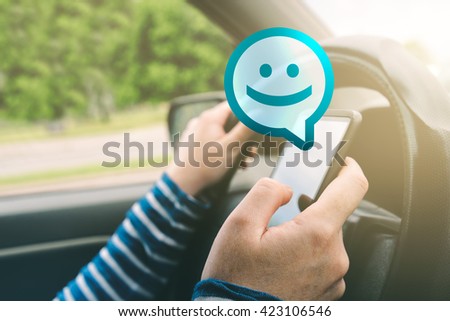 Foto d'archivio: Female Driving Car And Receiving Smiley Emoticon Message On Smar