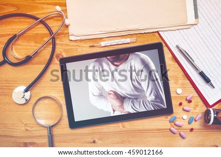 Foto stock: Tablet Computer With Picture Of Man Having Pain In Abdomen