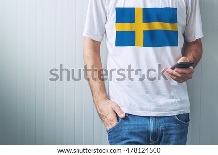 Stock photo: Casual Man With Swedish Flag On Shirt Using Mobile Phone