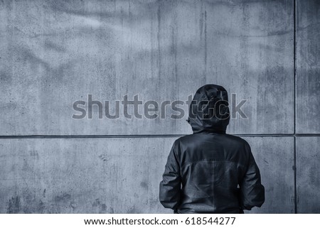 Foto d'archivio: Unrecognizable Hooded Female Person Facing Concrete Wall As Insu