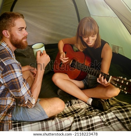 Сток-фото: Happy Young Looking At Her Boyfriend Playing Guitar By Tent