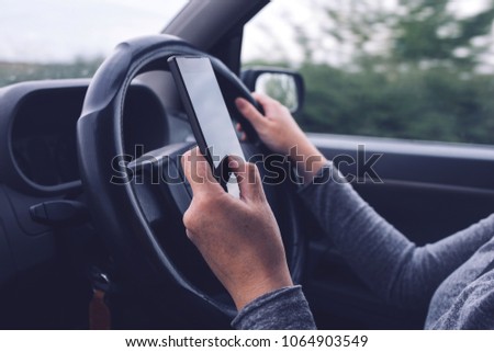 Foto stock: Woman Simultaneously Driving Car And Typing Text Message