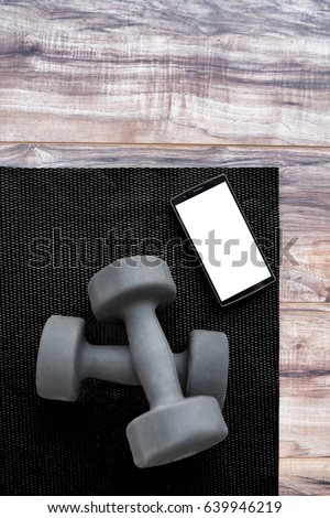 Gym Dumbbells On Fitness Mat Showing Phone App Weights On Exercise Yoga Mat And Smartphone For Heal Stockfoto © Maridav