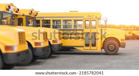 Stok fotoğraf: American Typical School Buses Row In A Parking Lot