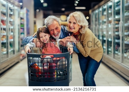 Stock photo: Little Girl Goes For Drive On Shoppingcarts In Supermarket