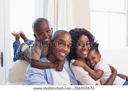 Stockfoto: Portrait Of Happy African American Family Sitting On The Sofa And Looking At Camera In A Comfortable