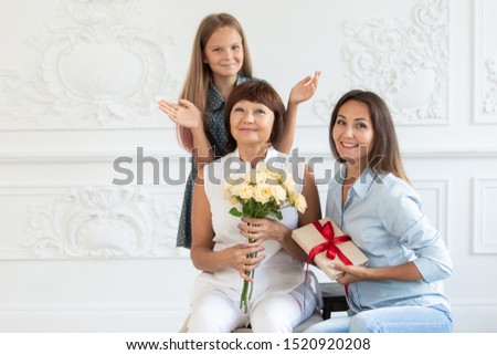 [[stock_photo]]: Young Mother Looking At Giftbox In Her Hands Surrounded By Husband And Daughter