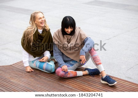 ストックフォト: Beautiful Woman Wears Knitted Sweater And Scarf Sits On Suitcase Near Platform Holds Smart Phone I