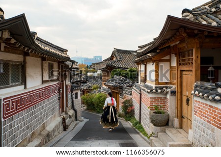 Stock photo: Young Woman Tourist In Bukchon Hanok Village Is One Of The Famous Place For Korean Traditional House