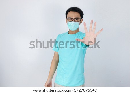 Stock fotó: Young Asian Man Wear Hygienic Mask Is Scared Or Panicking With Gesturing Stop Hand Afraid Of Corona