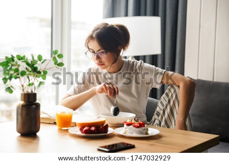 Stock foto: Photo Of Young Focused Woman Reading Book While Having Breakfast