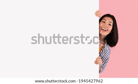 Foto stock: Casual Woman Peeping Over A Billboard