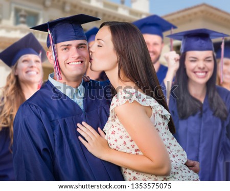 Zdjęcia stock: Proud Male Graduate In Cap And Gown With Girl Among Other Gradua