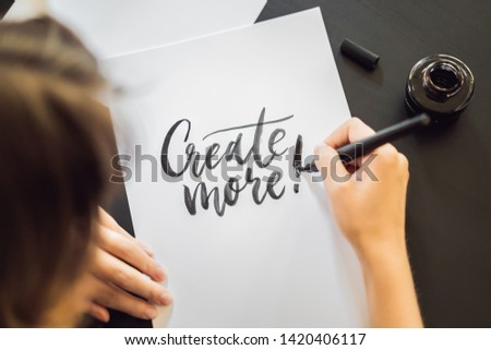 Foto stock: Creat More Calligrapher Young Woman Writes Phrase On White Paper Inscribing Ornamental Decorated L