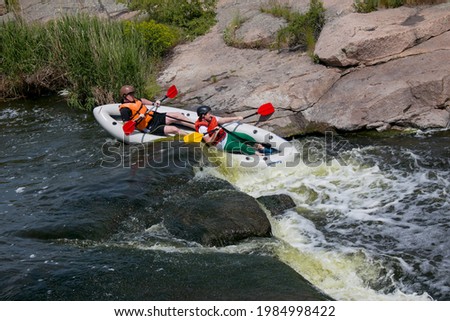 [[stock_photo]]: Young Woman Kayaking Down Waterfall