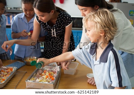 Stockfoto: Schoolchildren And Teacher At School In A Cooking Class