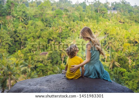 Foto stock: Mom And Son Tourists On A Stone Over The Jungle Traveling With Kids Concept What To Do With Childr