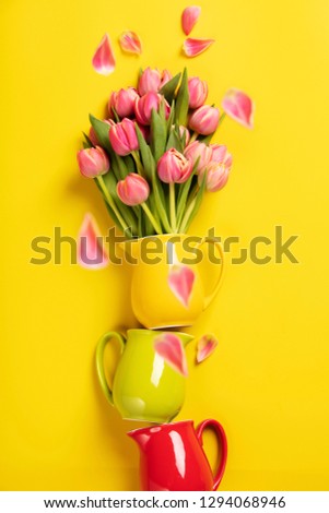 Foto stock: Perfect Pink Tulips In Colorful Jugs On Yellow Background