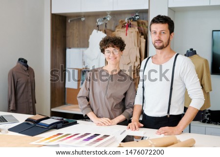 Two Young Creative Designers Of Clothing Items Standing By Desk Сток-фото © Pressmaster