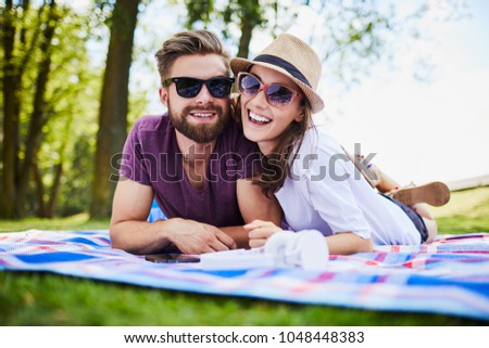 Zdjęcia stock: Portrait Of Happy Couple Wearing Sunglasses While Lying Together On Blanket At Beach