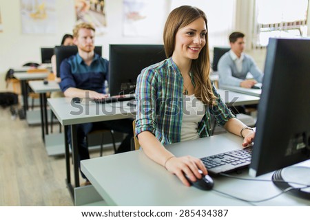 Foto d'archivio: Young Classmates Looking At A Monitor And Studying