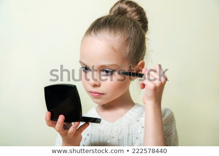 Foto stock: Little Girl Paints The Eyelashes Mascara