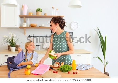 Stok fotoğraf: Beautiful Brunette Mother And Her Daughter Packing Healthy Lunch