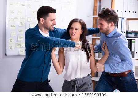 Foto stock: Businessmen Getting Into A Fight Woman Trying To Separate Them