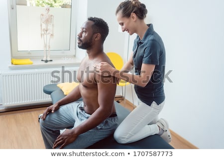 [[stock_photo]]: Physical Therapist Massaging A Young Black Man On Shoulder