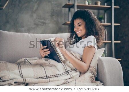 Сток-фото: Brunette Reading Book On Couch